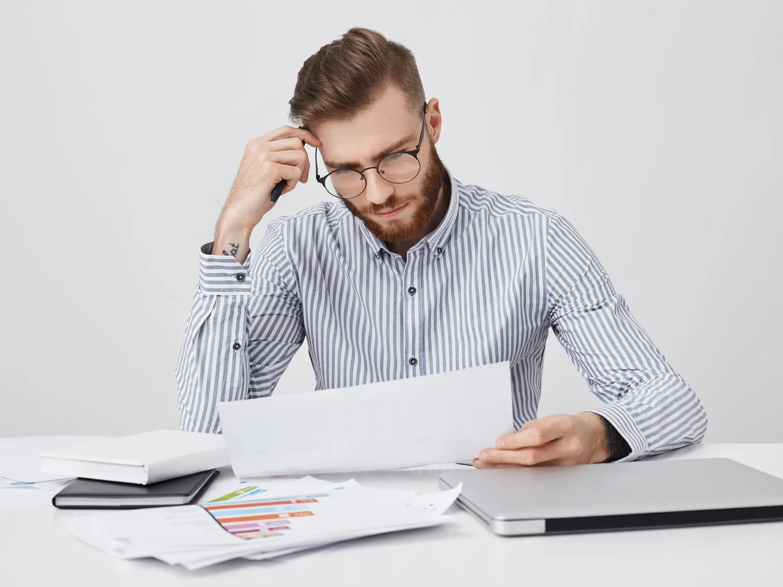 Bearded man in glasses reading document about personal accident insurance