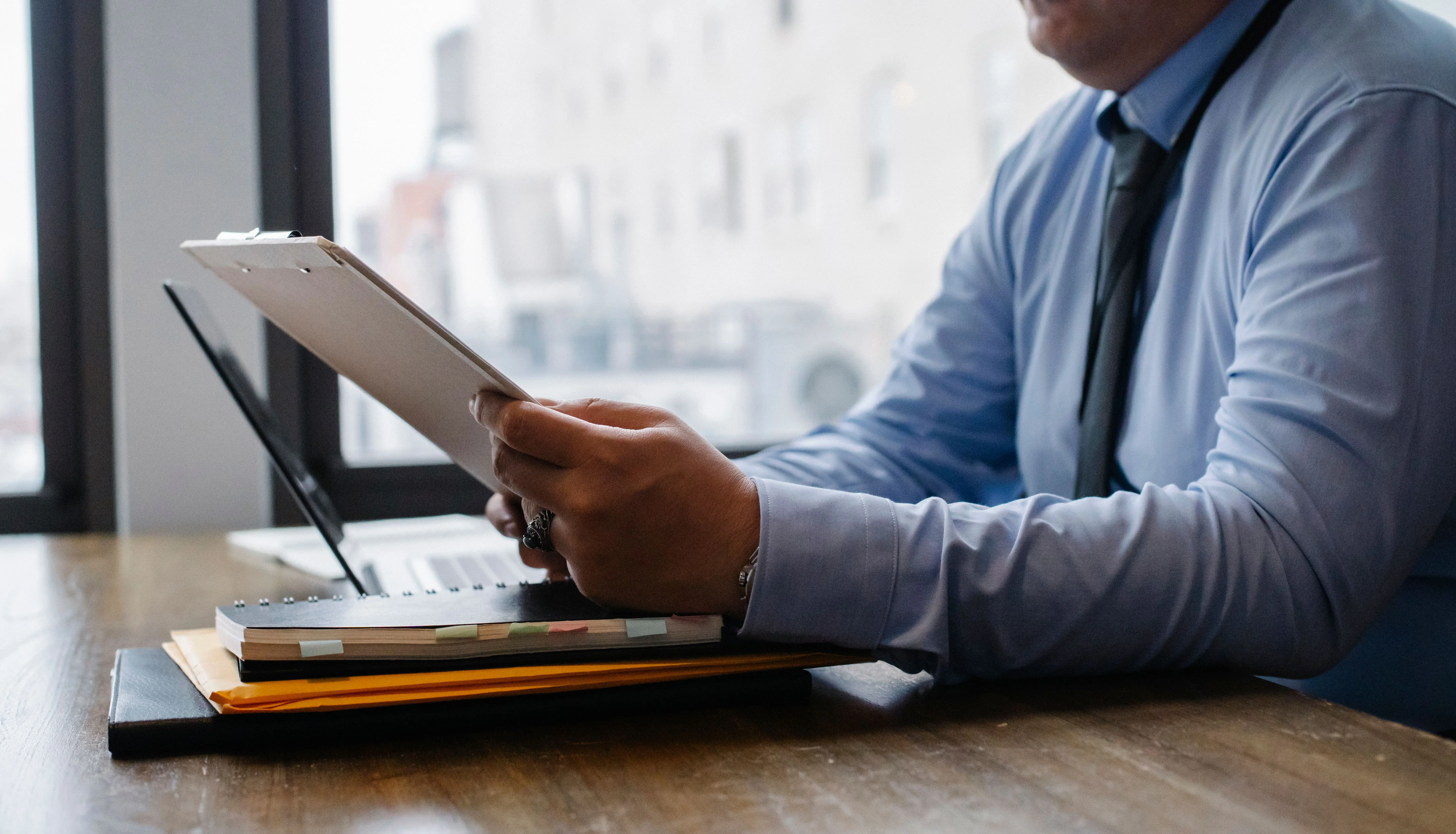 close up of business man in suit looking at clipboard