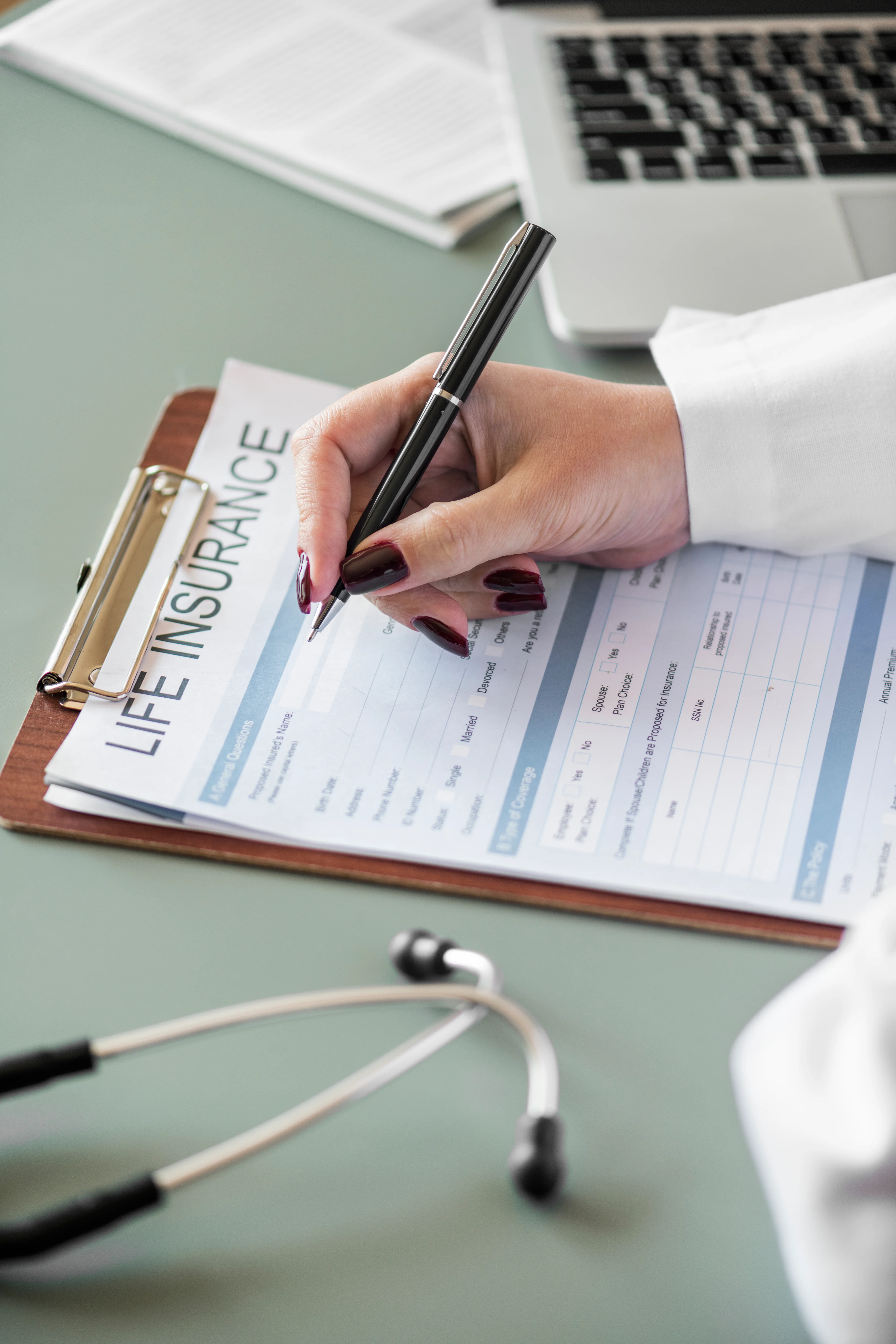 close up of client filling out life insurance paperwork