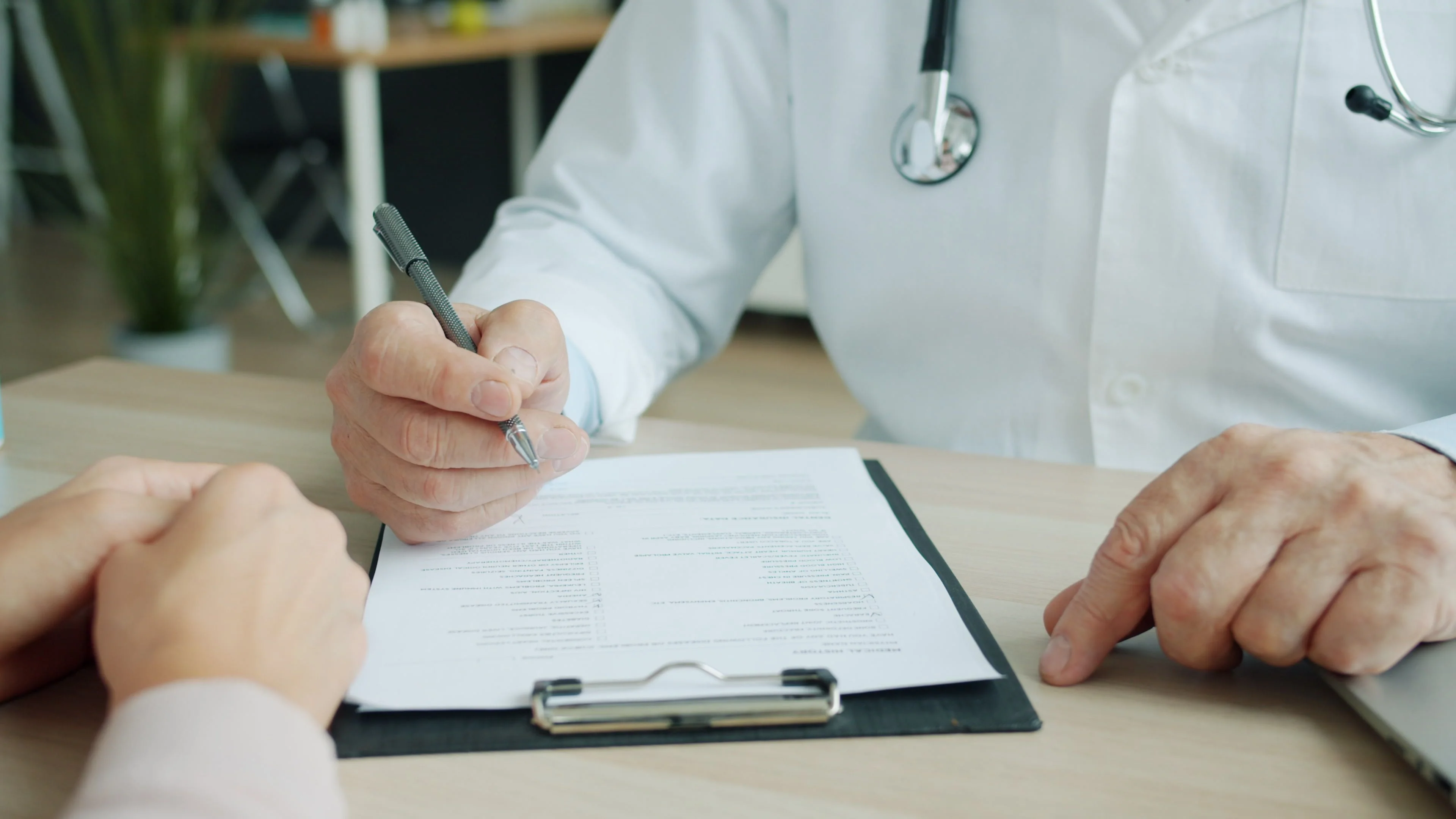 close up of doctor reviewing health insurance paperwork