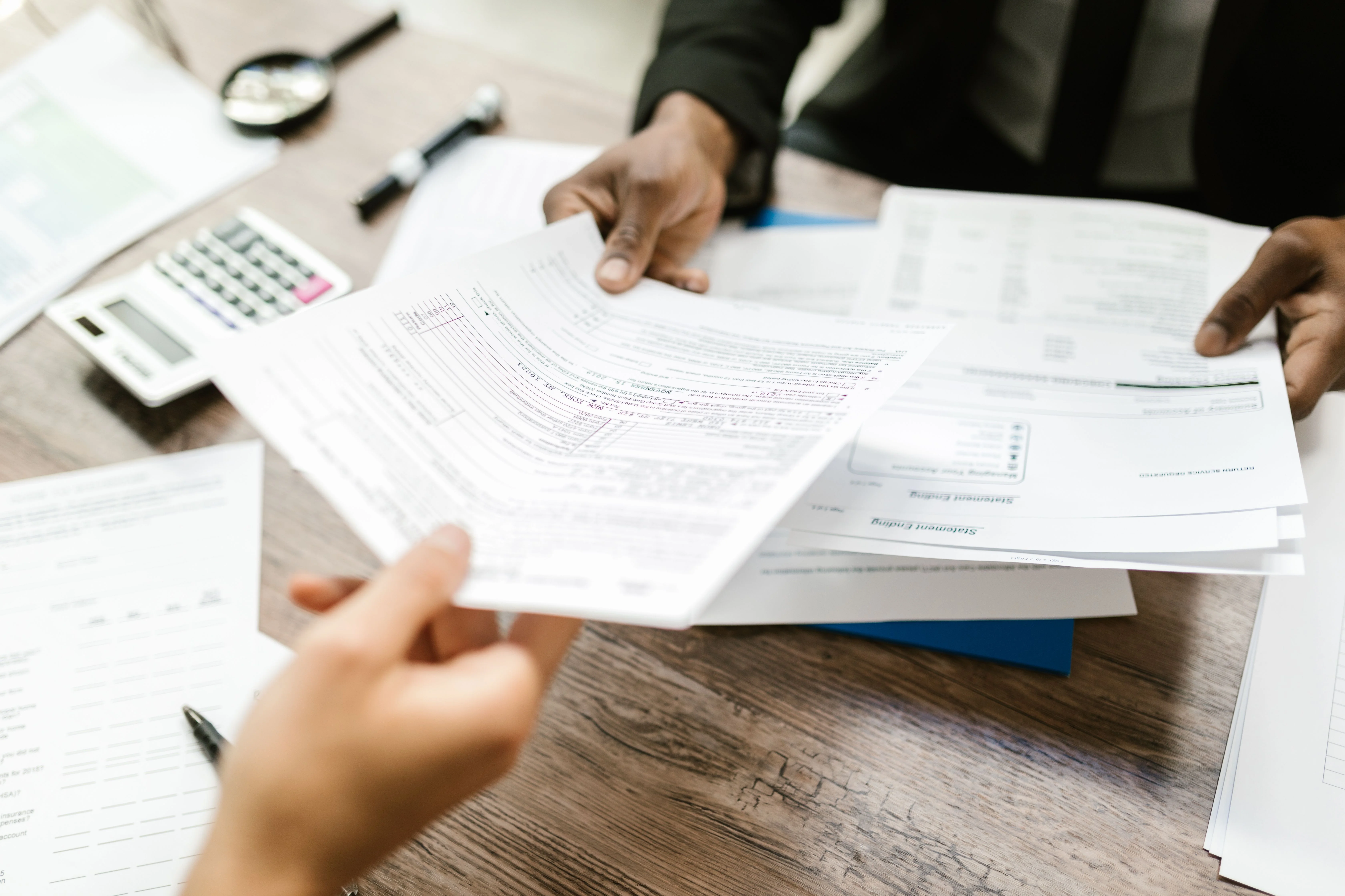 Close up of man handing deductible paperwork to client