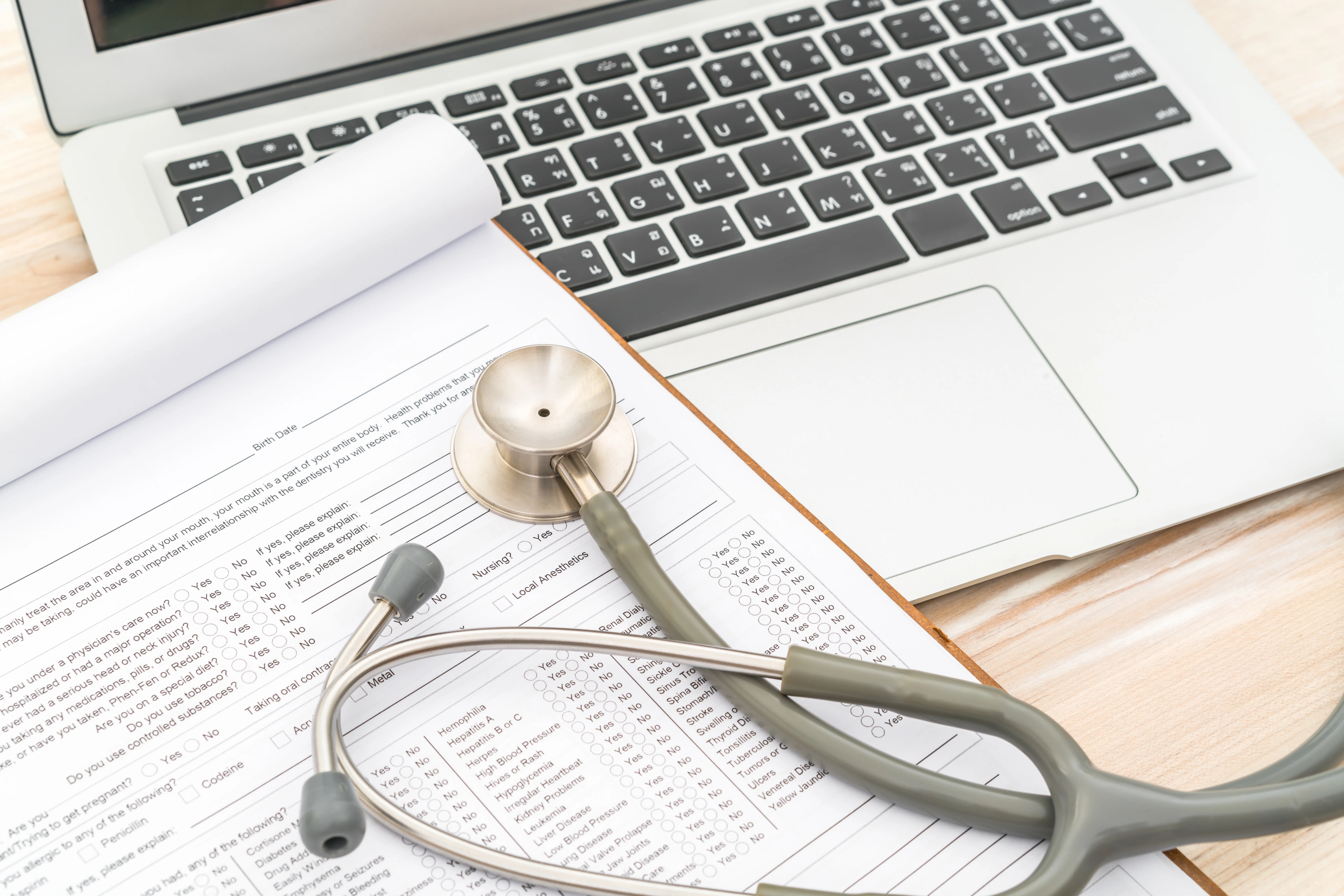 closeup of stethoscope and laptop on desk