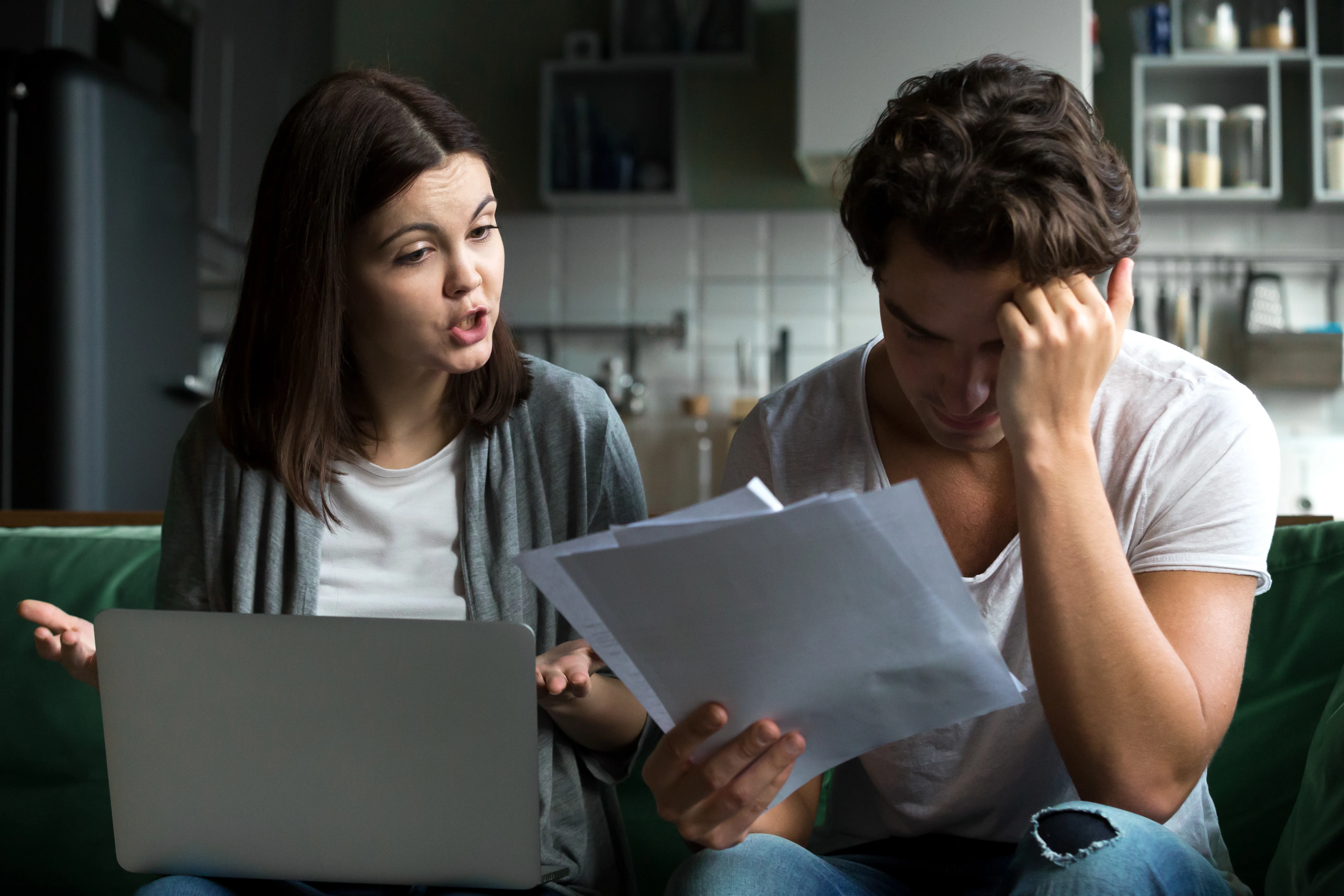 Couple analyzing insurance paperwork confused on if it is illegal to not have insurance