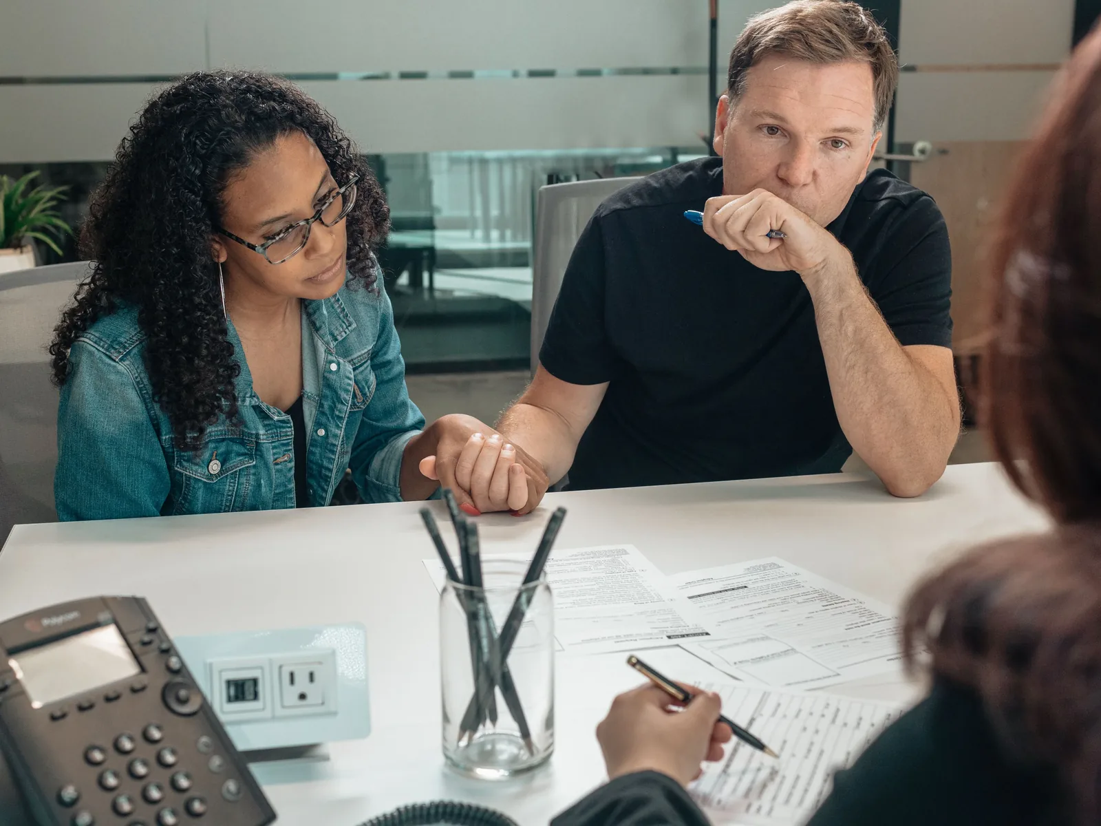 Couple holding hands while reviewing forms with advisor about federal poverty limit