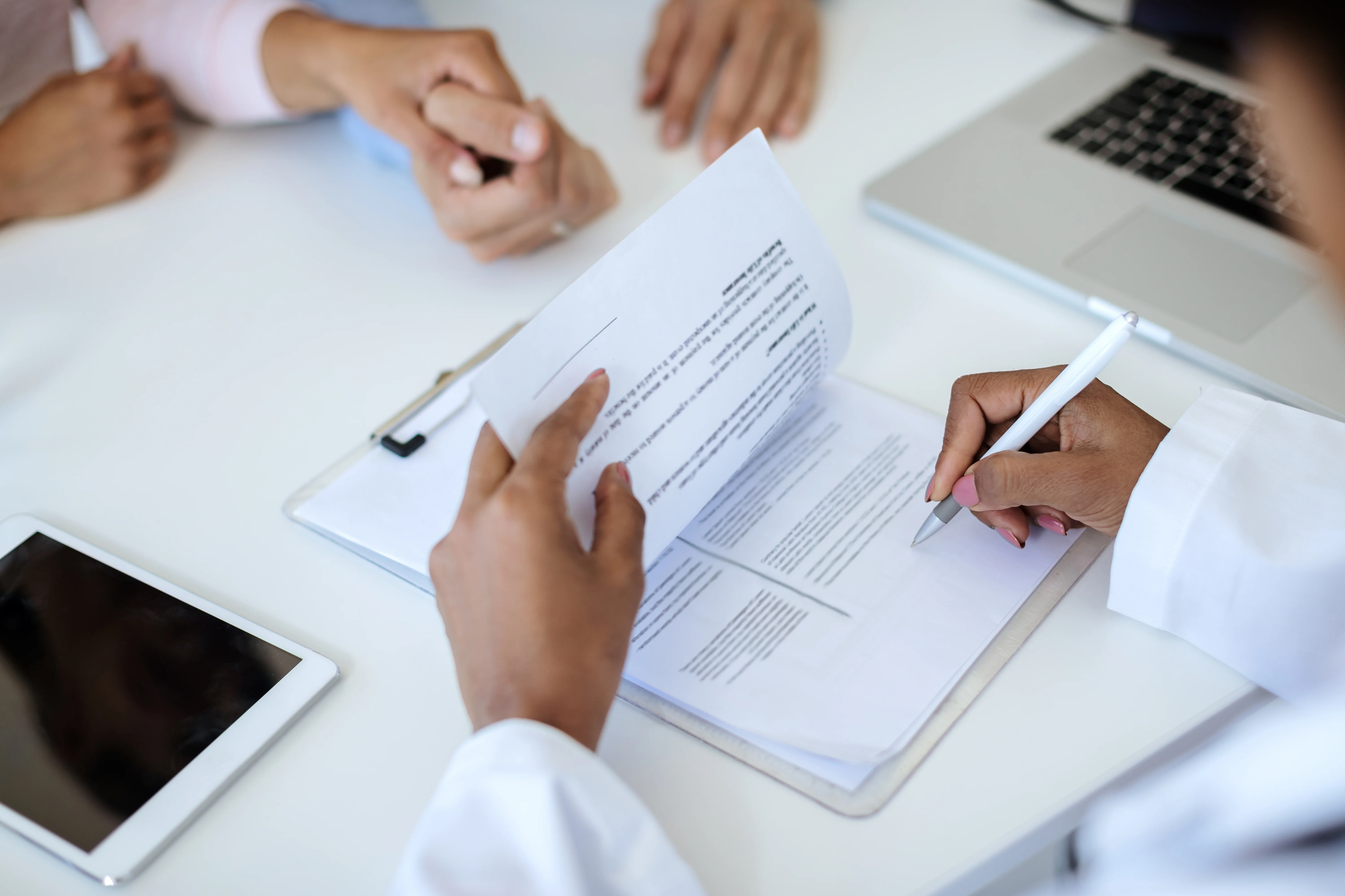 Female doctor reviewing clients health insurance paperwork