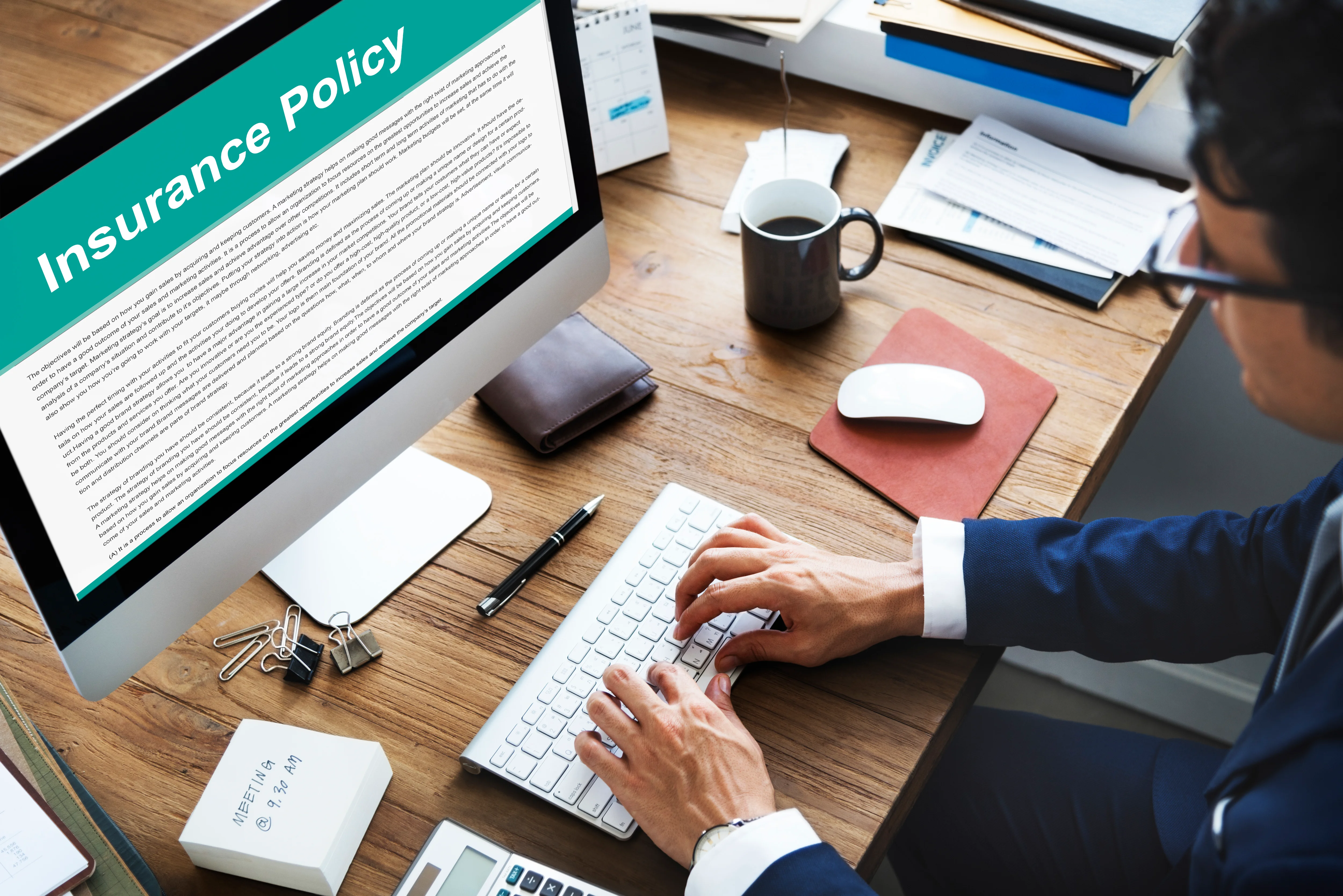 man searching insurance policy information on computer at desk
