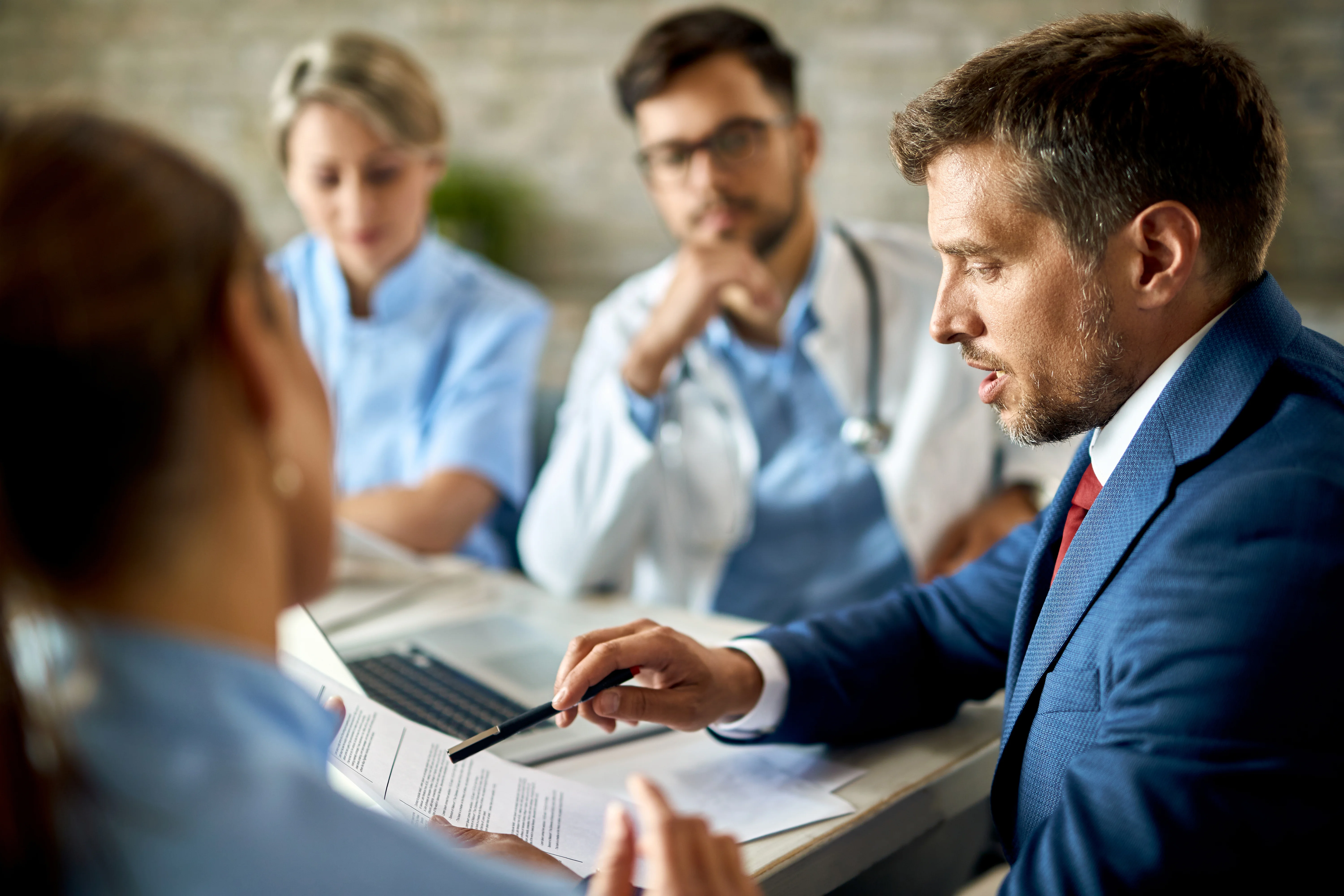 mid adult businessman healthcare workers analyzing documents meeting office