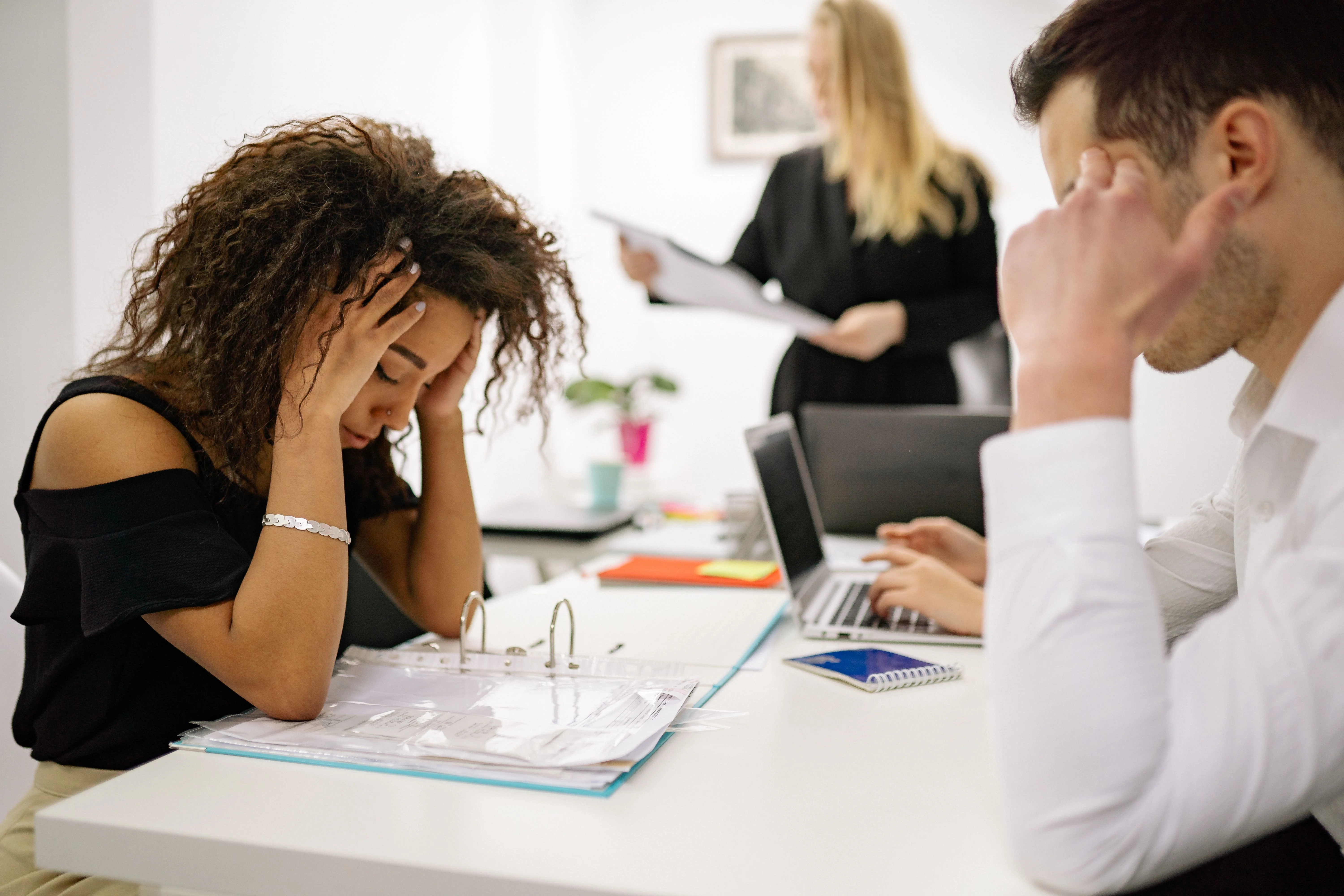women with hands on head stressed on how to get temporary health insurance between jobs